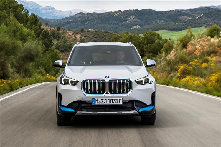 BMW IX1 driving on a country road.