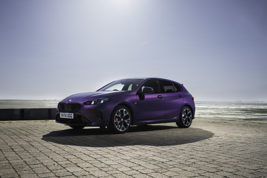 BMW 2025 1 Series review- Side view of 2025 BMW 1 series stationary on pavement road with blue cloudless sky