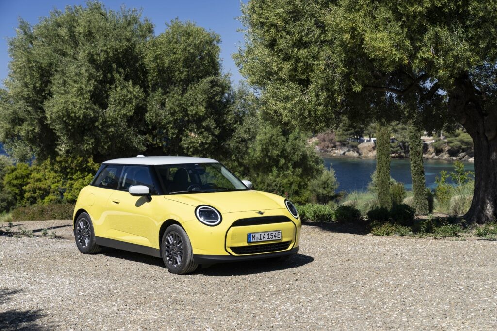 2024 Mini Cooper Hatchback in vibrant colour parked on a scenic road.