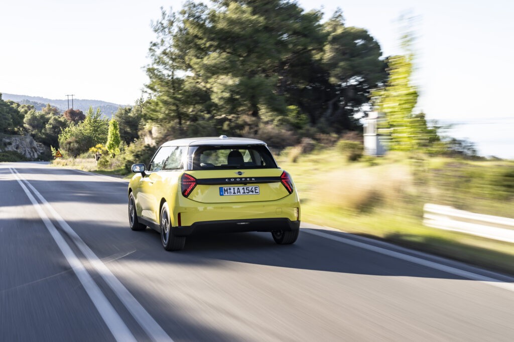 2024 Mini Cooper Hatchback in vibrant colour parked on a scenic road.