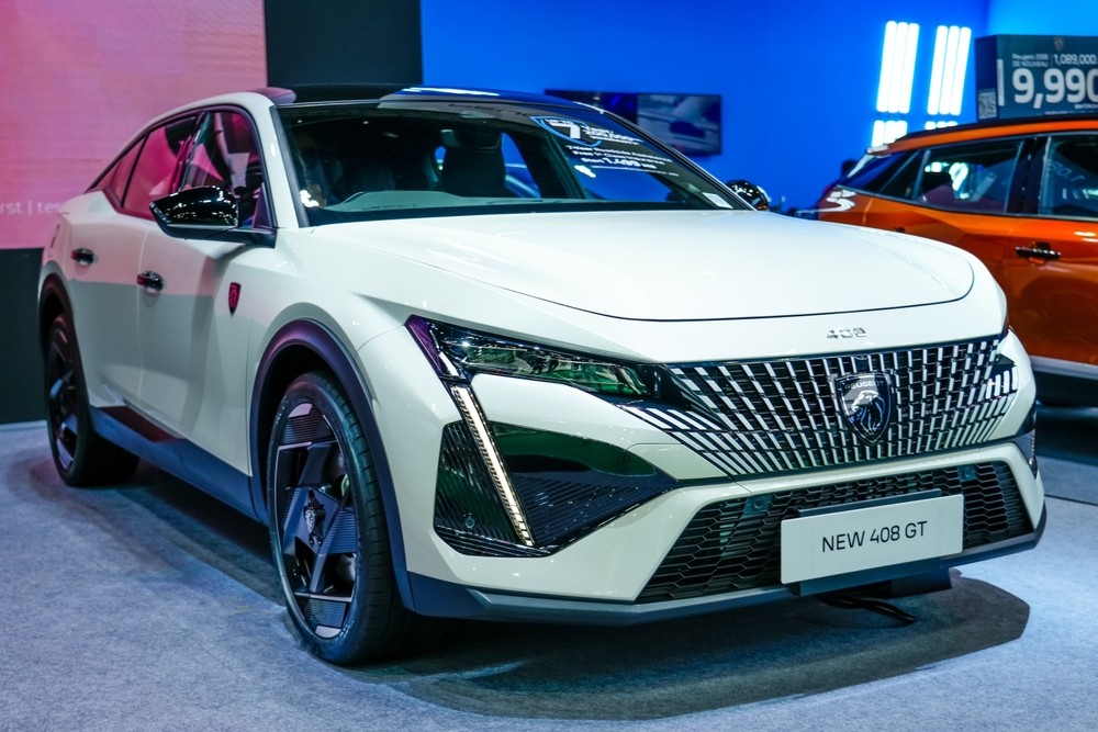 A sleek Peugeot 408 hybrid showcasing its fastback design in an urban setting.