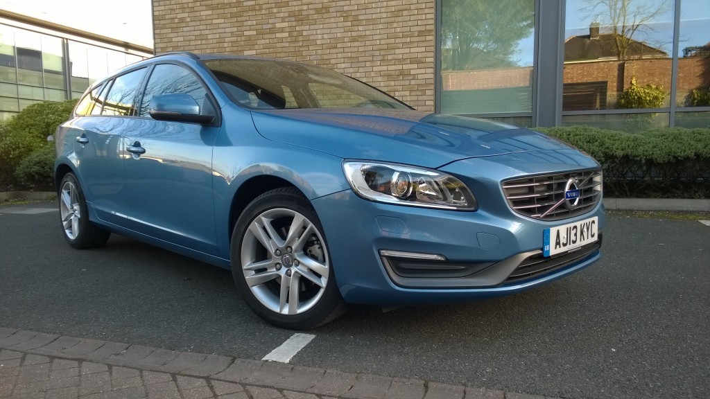 silver blue executive car in front of a building